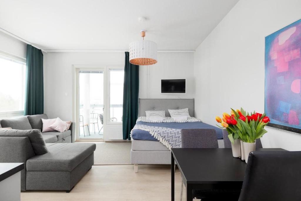 埃斯波New 2BR design home with sauna Espoo Park的一间卧室和一间带床和沙发的客厅