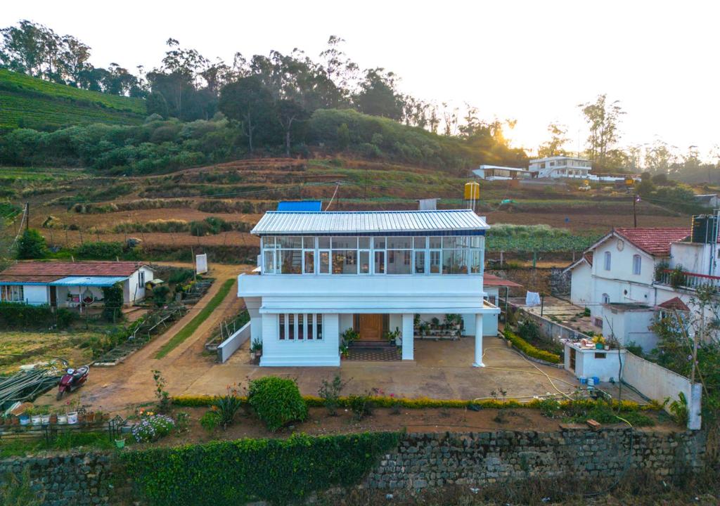 乌提Autumn Farm Villa Ooty by VOYE HOMES - NB - 200 Meters Walkable Distace From The Parking Area的山顶上一座白色的大房子