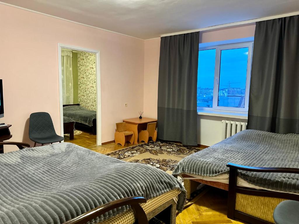 罗夫诺4-км в центрі міста的一间卧室设有两张床和窗户。