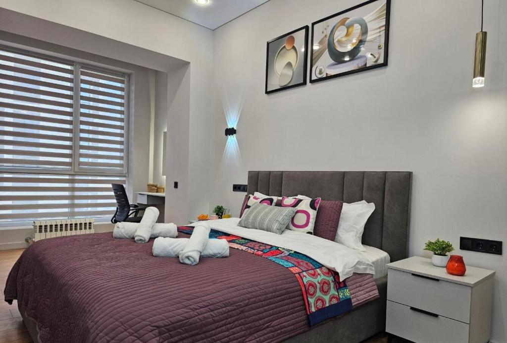 阿拉木图ЖК Комфорт Сити Бизнес, 2 room Apartment 47的卧室配有一张带白色粉色枕头的大床