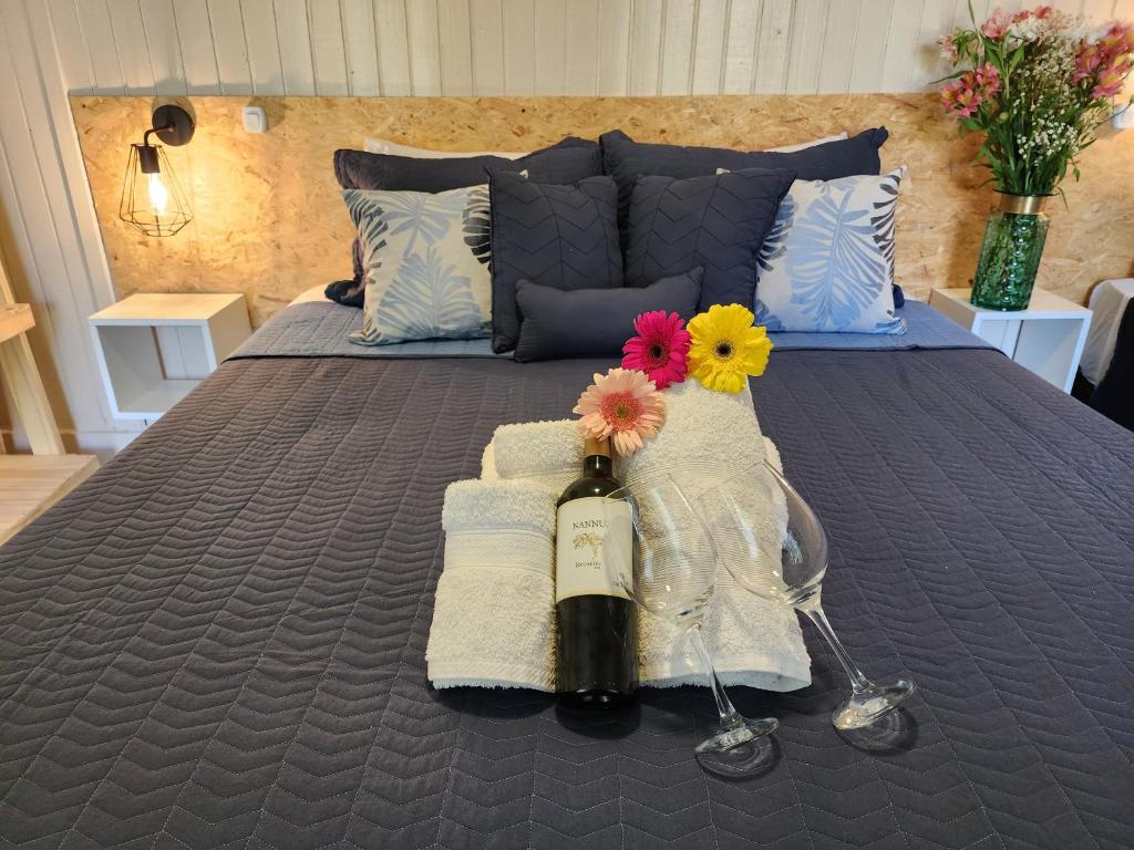 门多萨Casa Aqua hotel boutique的床上有一瓶葡萄酒和鲜花