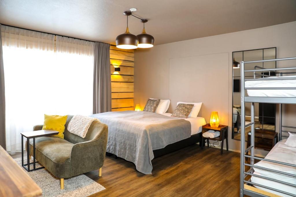 阿克雷里Akureyri Hostel的一间卧室配有一张床、一张沙发和一把椅子