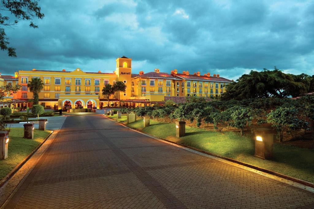 圣何塞Costa Rica Marriott Hotel Hacienda Belen的前面有一条街道的大型黄色建筑
