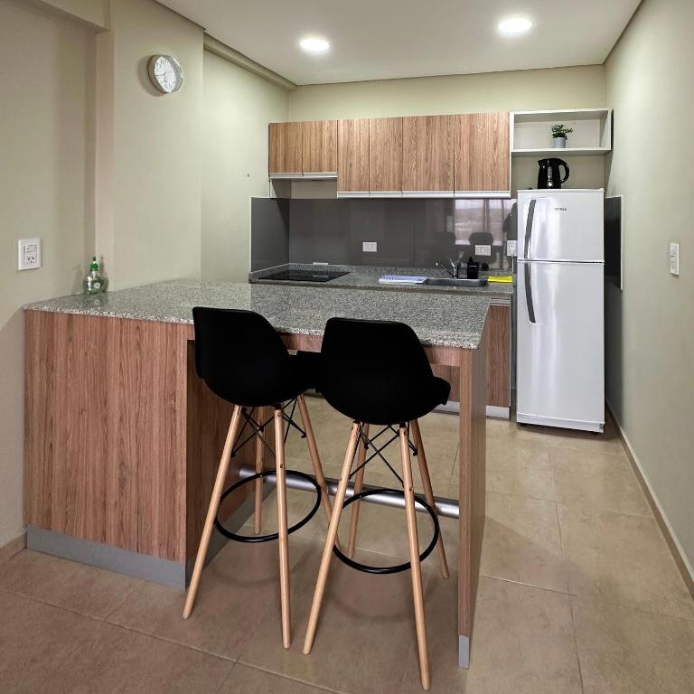 福尔摩沙Costado Norte的厨房配有冰箱的柜台,设有两个黑色凳子