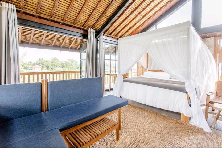 NgaglikBaku living villa的一间卧室配有一张床,卧室配有长凳