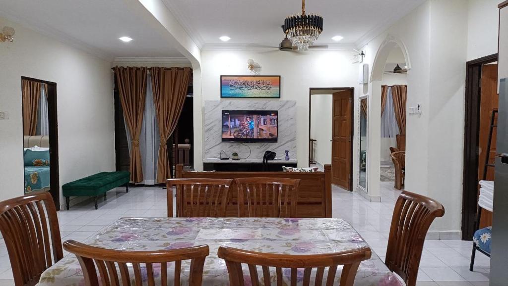 马西Rinting Corner Islamic Homestay, Pasir Gudang的一间带桌子和电视的用餐室