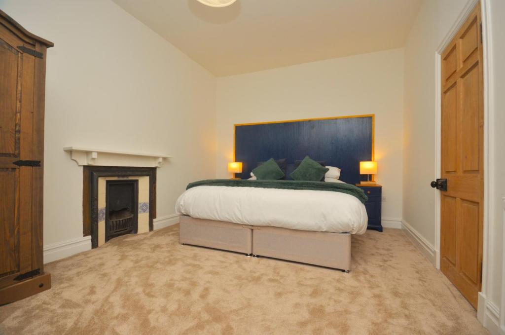 海伦斯堡The Gate Lodge的一间卧室设有一张大床和一个壁炉