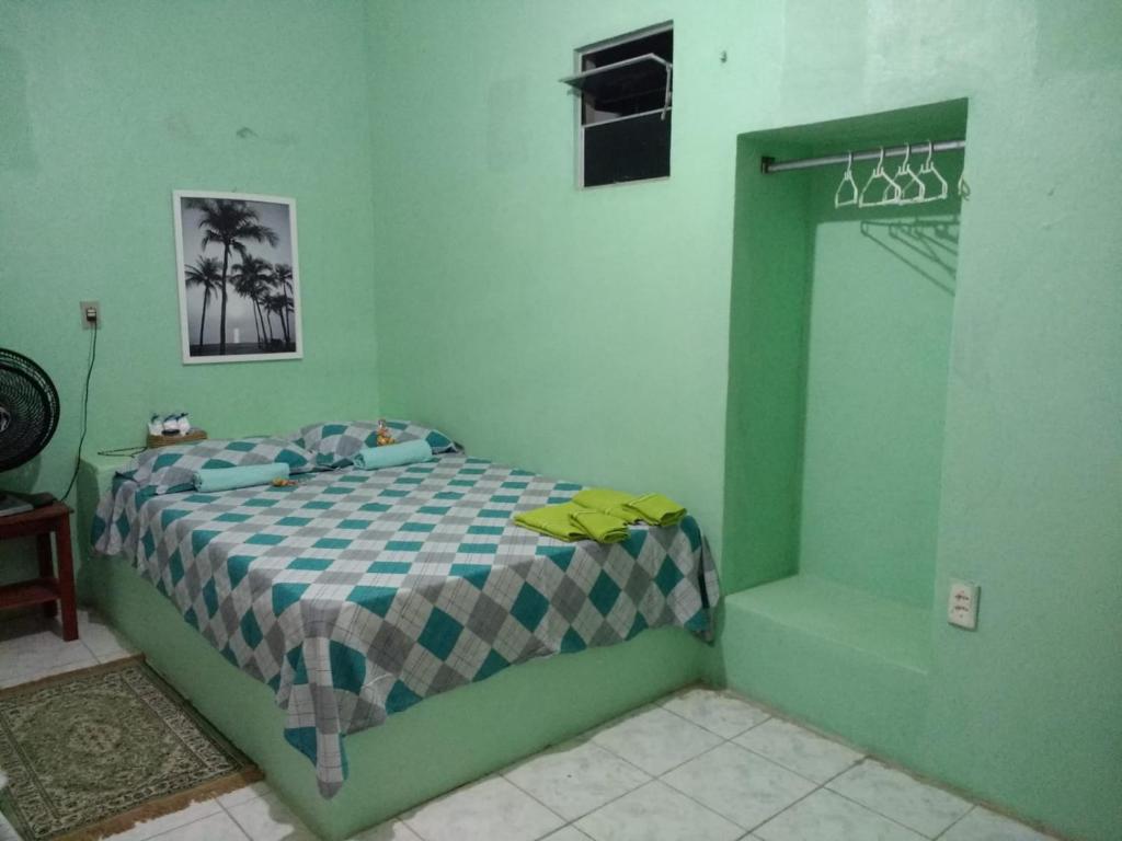 卡斯卡韦尔Casa Laranja的一间位于绿色客房内的卧室,配有一张床