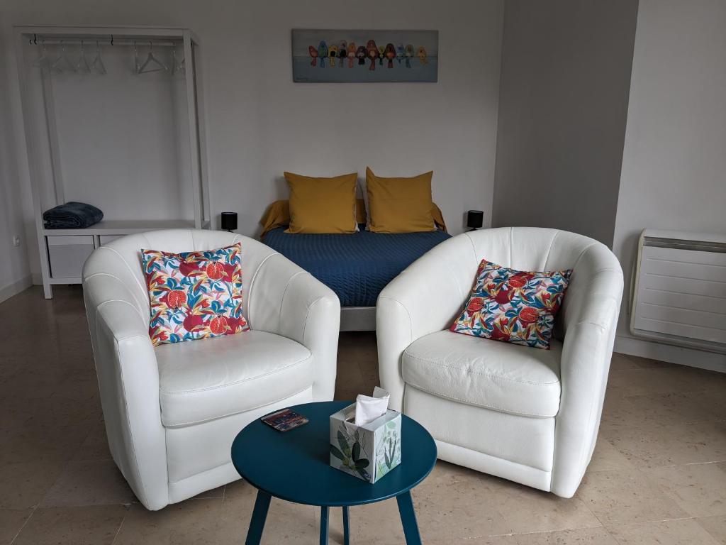 拉罗什波赛Les Jolis Nids - Studio Rouge Gorge的客厅配有两把椅子和一张桌子
