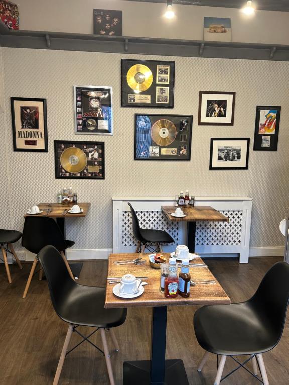 惠特比The Woodszz guest house的餐厅设有桌椅,墙上挂有图片