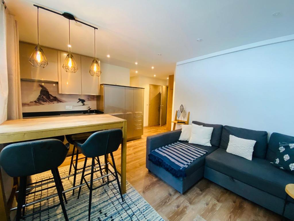采尔马特Cosy Modern Apartment with balcony and Matterhorn View的一间带蓝色沙发的客厅和一间厨房