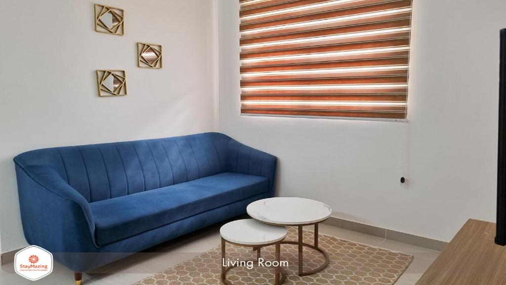 班加罗尔StayMazing Manyata-1BHK Boutique AC Apartments -Couple Friendly的客厅配有一张蓝色的沙发,配有一张桌子