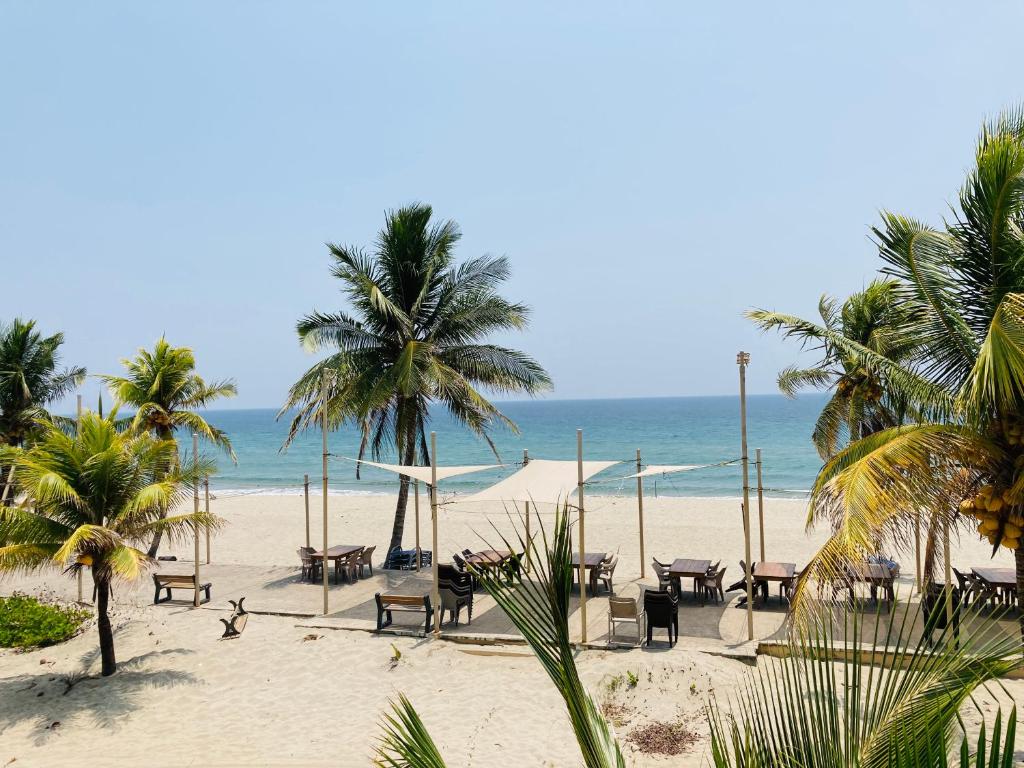 特拉Honduras Shores Plantations的海滩上设有桌椅,大海上设有沙滩