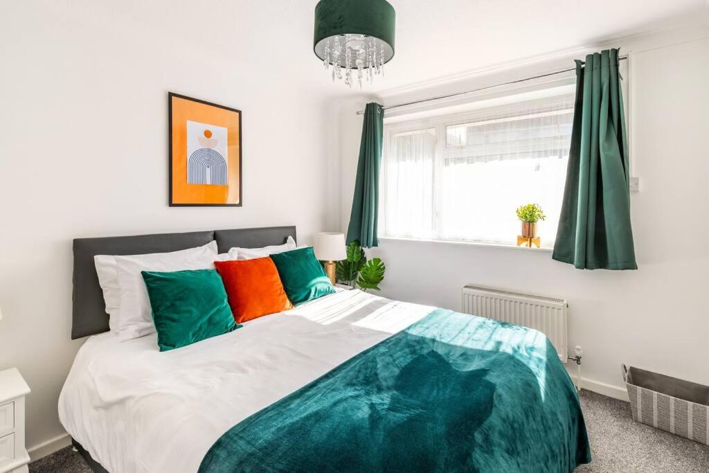 查塔姆Ark on the Hill的一间卧室配有一张带绿色和橙色枕头的大床