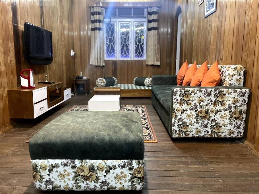 甘托克The First House - 2 BHK in Main Gangtok的客厅配有两张沙发和一台电视机