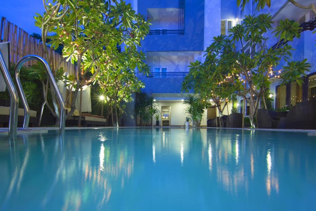金边诺罗敦大道阿尼克精品水疗酒店的一座树木繁茂的大型游泳池和一座建筑
