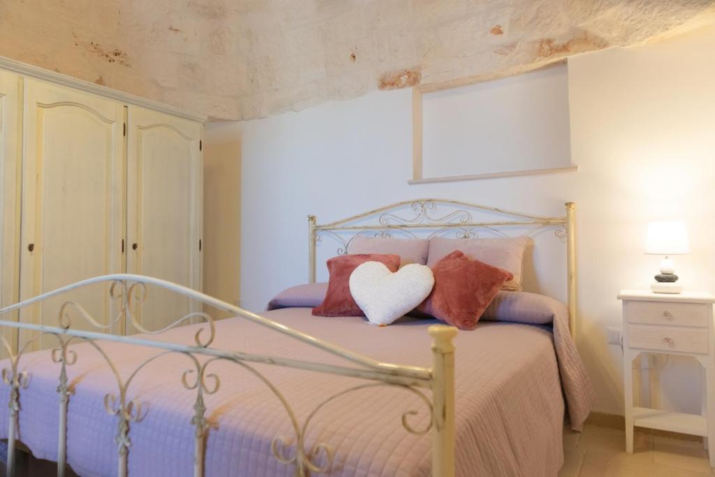 奇斯泰尼诺Masseria Carperi in the heart of Valle d'Itria的一间卧室配有一张带两个枕头和心枕的床