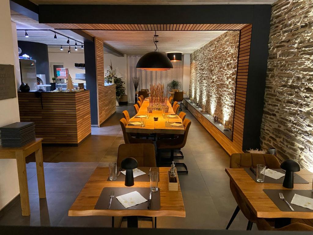 埃尔伯蒙Le Cerf d'Or的一间带桌椅的餐厅以及砖墙