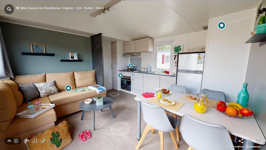 圣让-德蒙Mobil Home Le Rimbaud - 4/6 pers - 2 ch - 2 sdb的厨房以及带桌子和沙发的客厅。