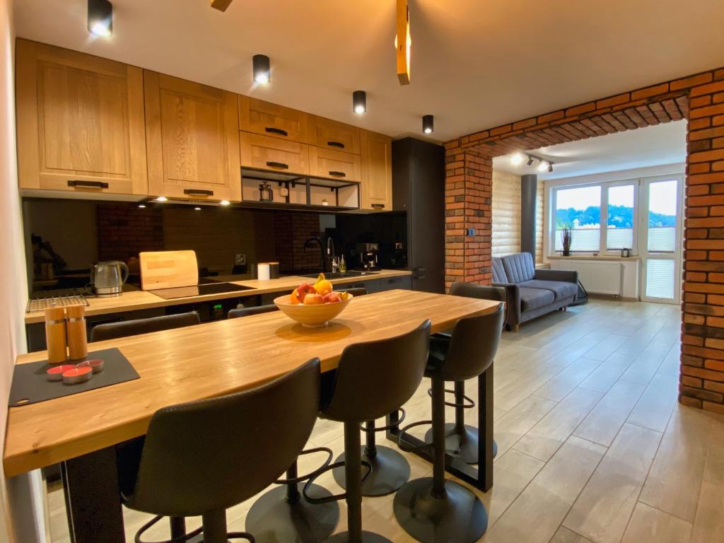 克雷尼察Apartament Góral的厨房以及带木桌和椅子的客厅。