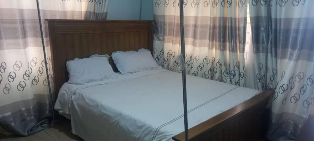 MbaleNelly Apartments的卧室内的一张带两个枕头的床