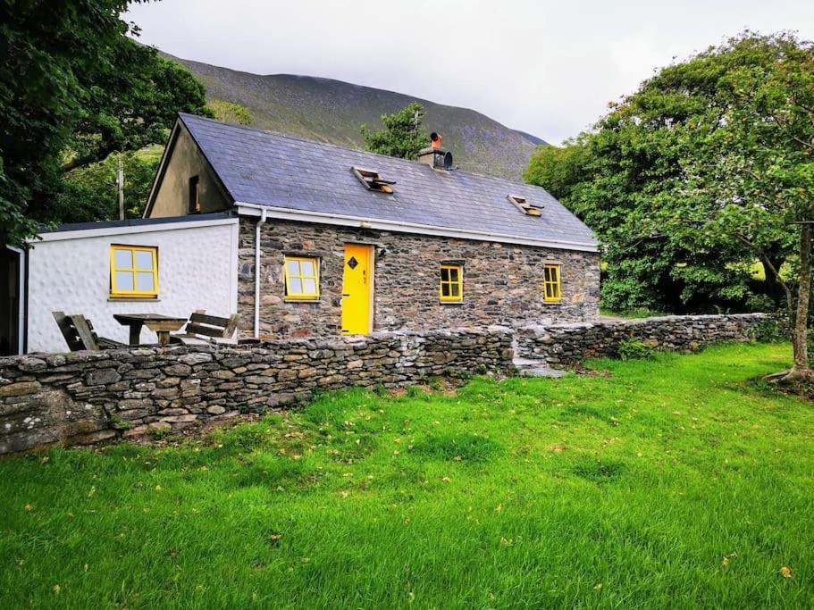 凯尔西温Cottage Skelligs Coast, Ring of Kerry的石头房子,上面坐着一个男人