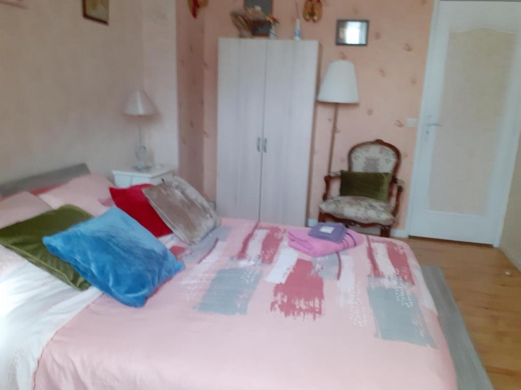 圣雷米·莱谢夫勒斯chambre d'hôte "Chambre dans une maison pleine de vie"的卧室配有白色的床和色彩缤纷的枕头