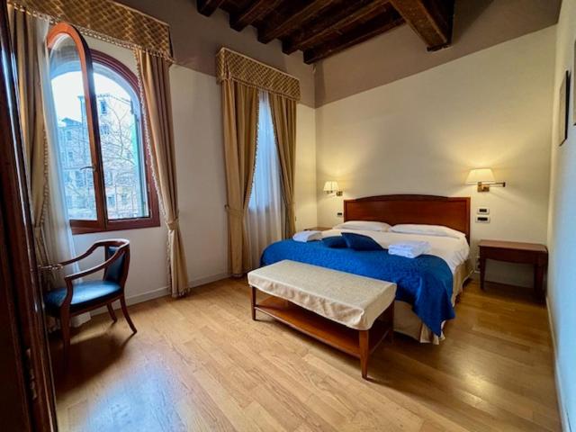 威尼斯洛坎达德尔盖托酒店的卧室配有床、椅子和窗户。