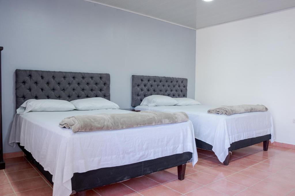 Santa AnaPosada La Rosa的白色墙壁客房的两张床