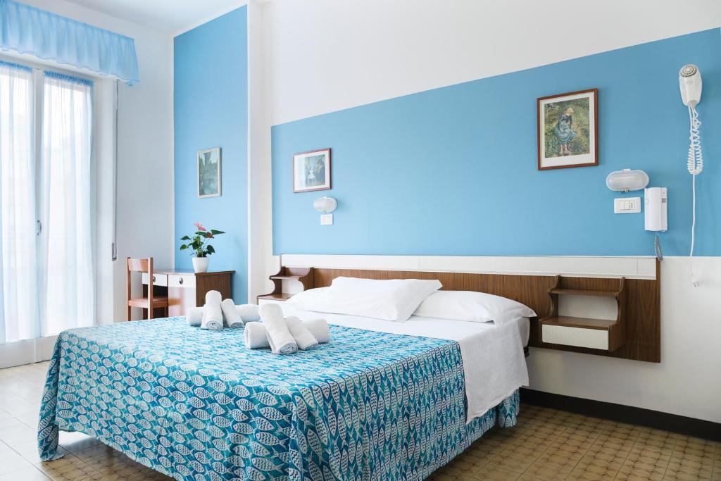 里米尼Hotel Cheri的蓝色的卧室,配有一张蓝色墙壁的床