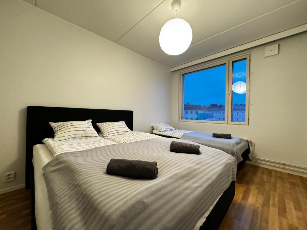 赫尔辛基DownTown Rooms And Sauna的带大窗户的客房内的两张床