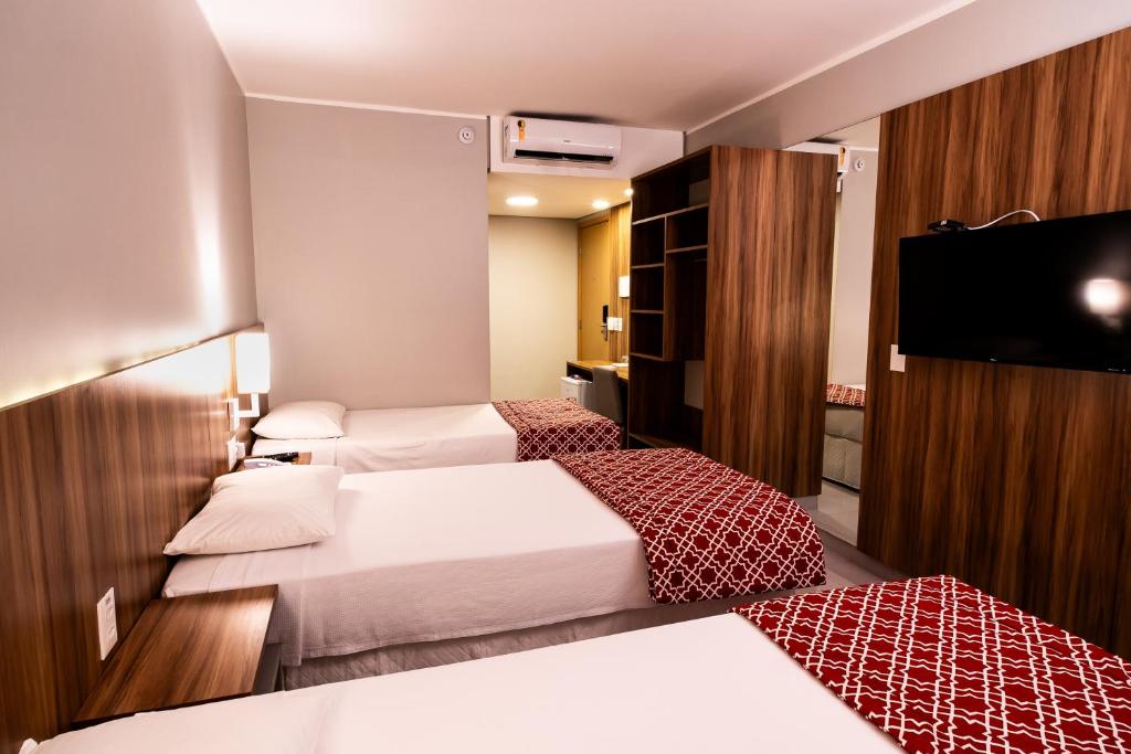 福塔莱萨Stop Way Hotel Fortaleza的酒店客房设有两张床和一台平面电视。