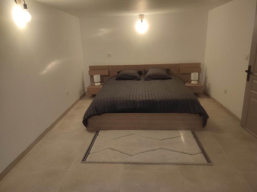 奥朗日LES JARDINS D'ORANGE的一间卧室配有一张带两盏灯和地毯的床。