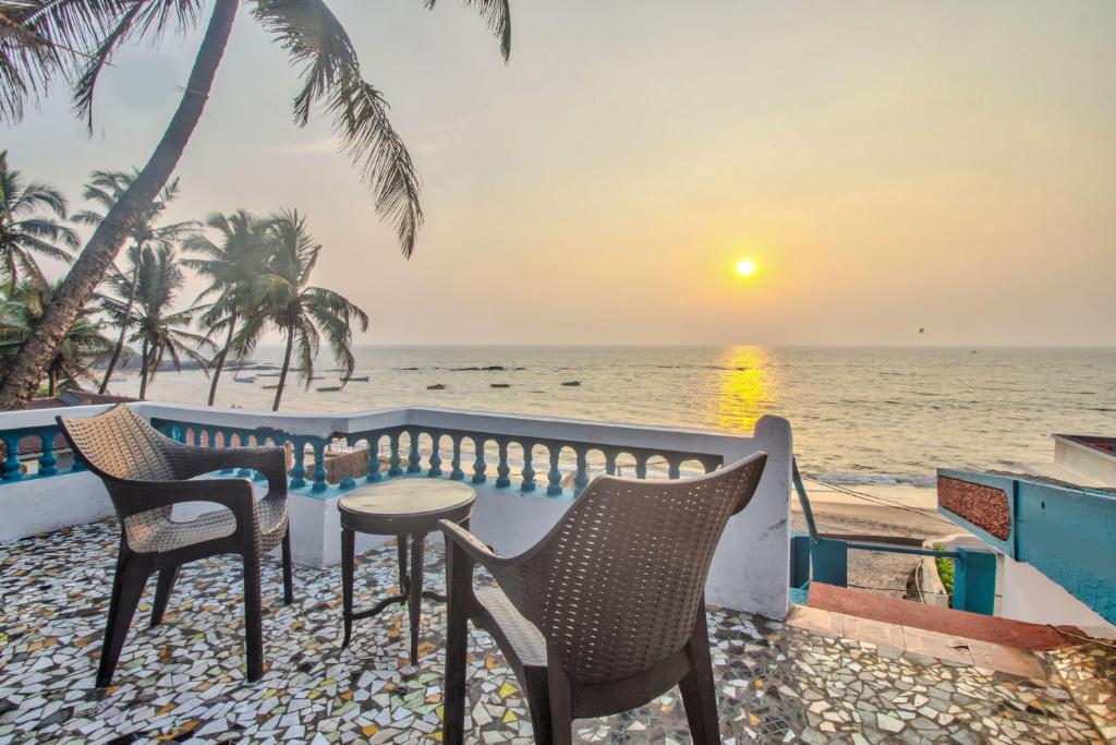 安君纳Villa Seafront Goa的俯瞰大海的阳台配有桌椅