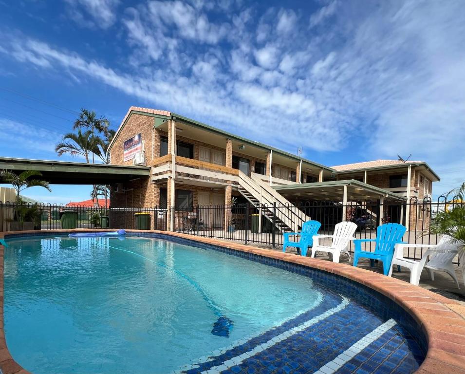卡伦德拉Golden Beach Motor Inn, Caloundra的一个带蓝色椅子的游泳池