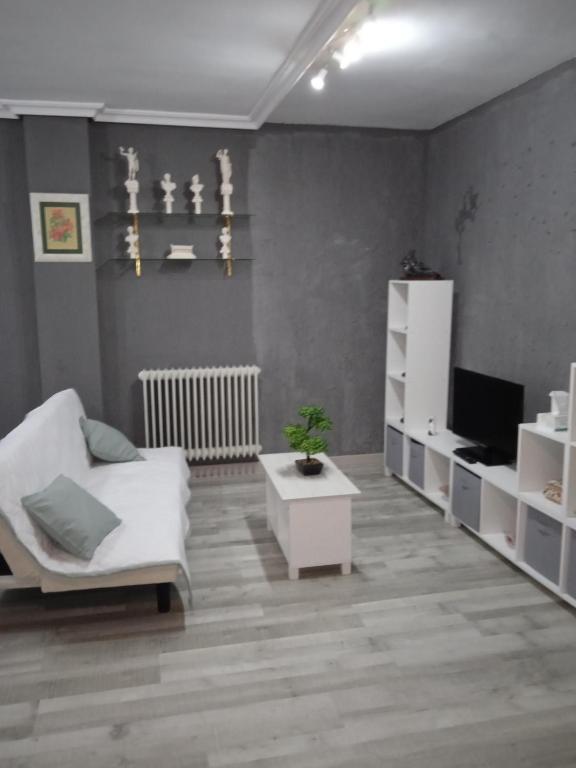 罗德里戈城Alojamiento Roma的客厅配有白色椅子和电视