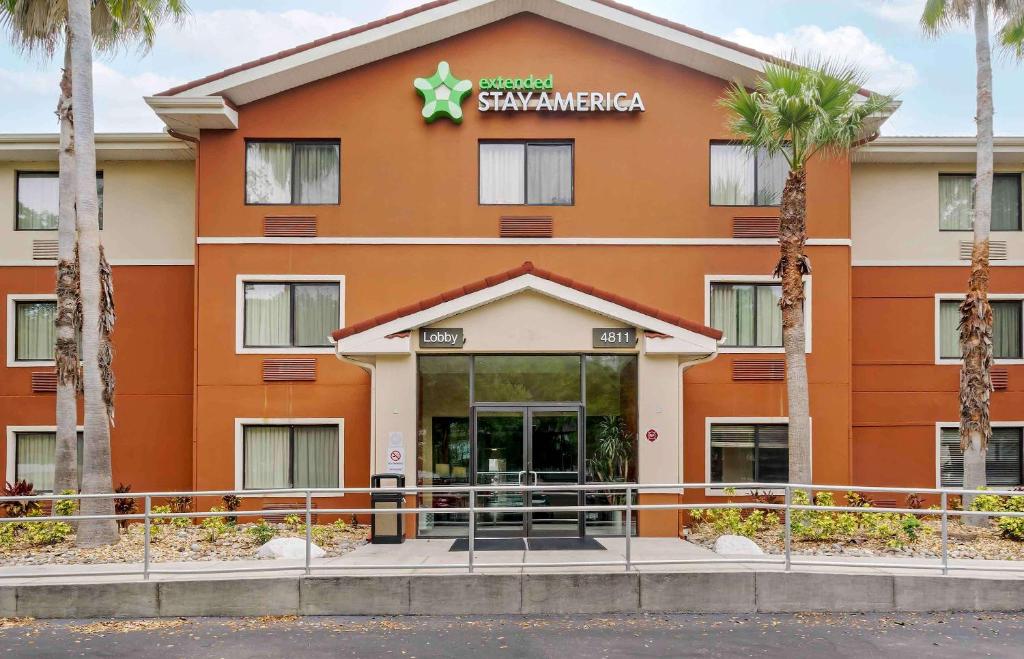 坦帕Extended Stay America Select Suites Tampa Airport Memorial Hwy的建筑前方有标志的酒店
