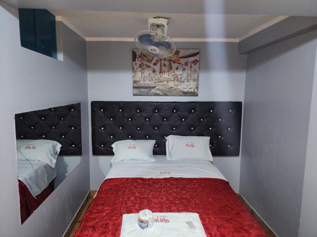 利马Hostal Paris的一间小卧室,配有一张带红色床罩的床