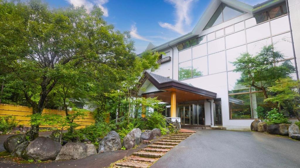 山中湖村Fuji Yamanakako Hotel的前面有岩石的白色建筑