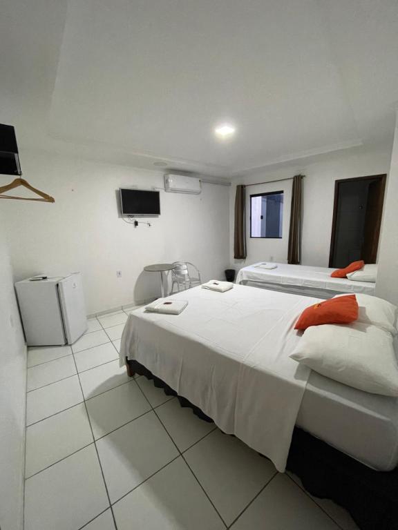 大坎皮纳Hotel Pousada Acauã Acesso através de escadas的一间酒店客房,设有两张床和电视
