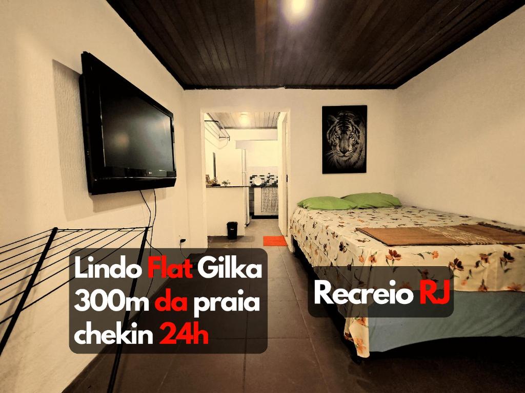 佩德拉德瓜德拉巴Lindo Flat2 a 300 mts da praia posto 12 Recreio的一间卧室配有一张床和一台平面电视