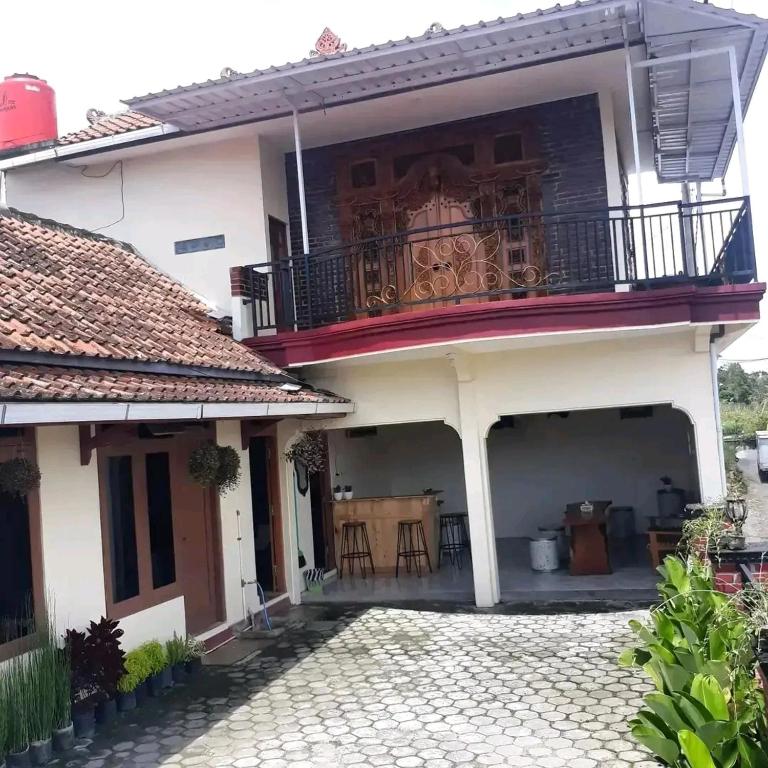 TambakrejoMAJA HOUSE 2的带阳台和庭院的白色房屋
