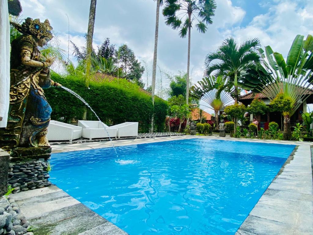 帕洋安Dong Loka Guesthouse Bali的一座房子前面的游泳池,喷泉