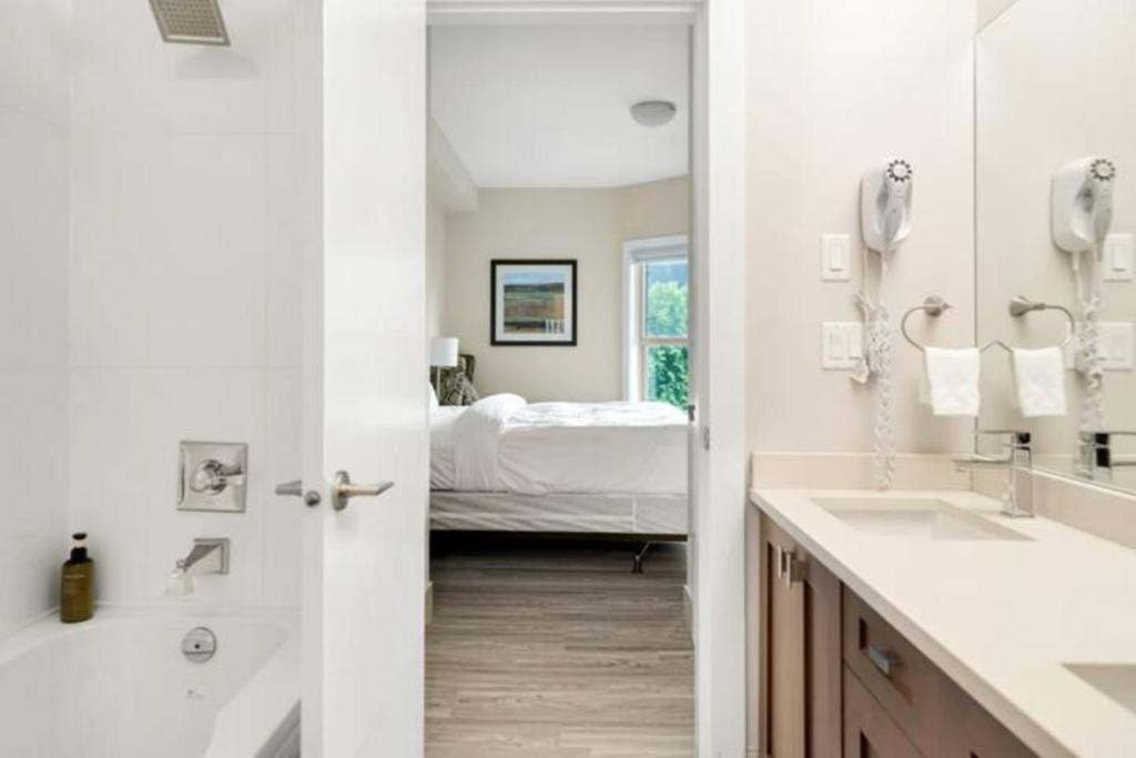 哈里森温泉Penthouse Lake Home - 3BR w/Amazing View & Deck!的一间带两个盥洗盆的浴室和一间带一张床的卧室