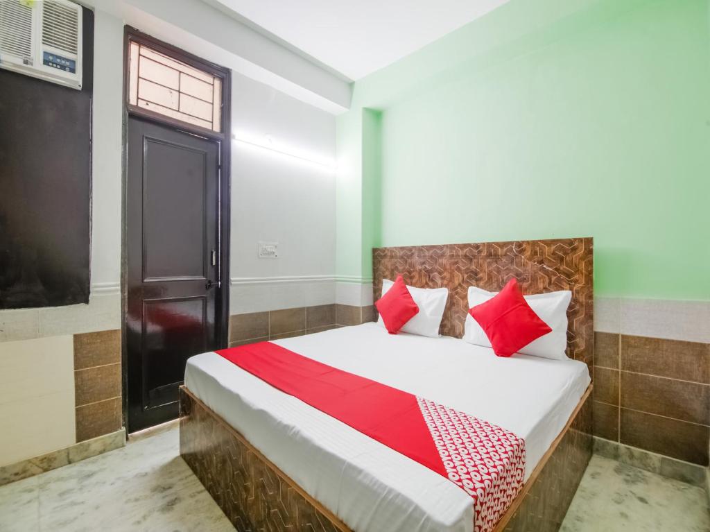 新德里OYO Flagship Hotel Green Light的一间卧室配有红色枕头的床