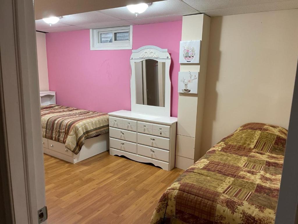 渥太华Cute 2 beds room , for females only的客房设有两张床和一个带镜子的梳妆台