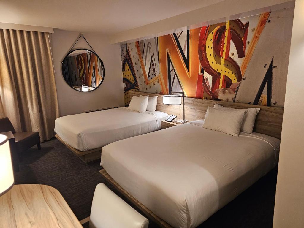 拉斯维加斯Coolest bar hoping Linq Casino Hotel Strip Las Vegas的酒店客房,设有两张床和镜子