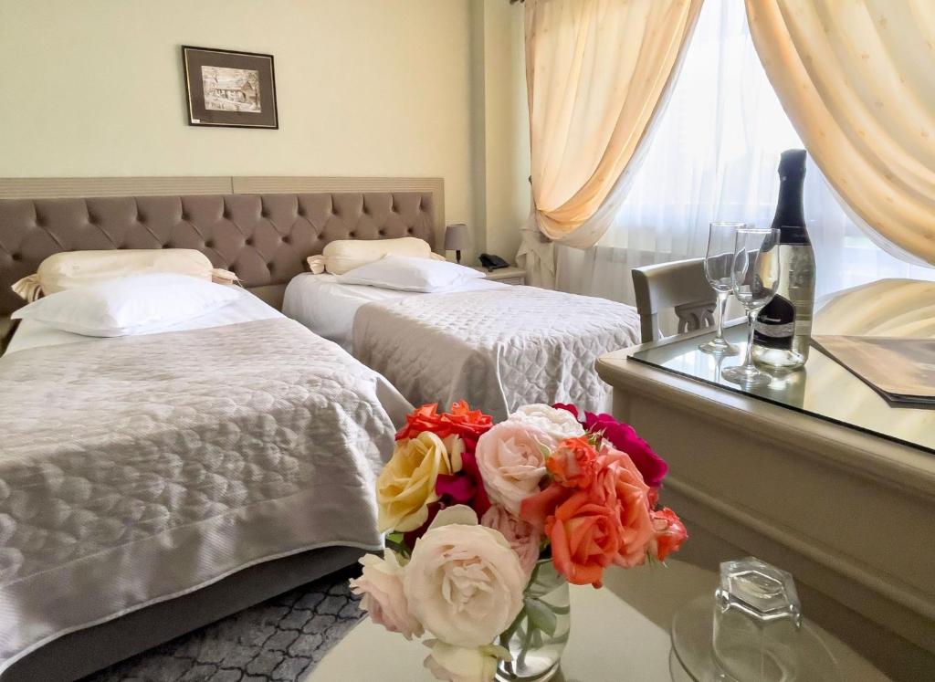 雅西号角汽车旅馆及Spa的酒店客房,设有两张床和一张鲜花桌。
