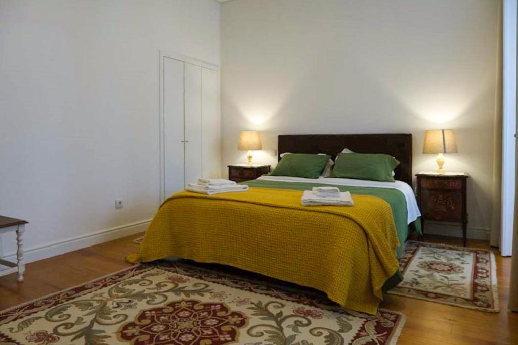 波尔图Casa Velha Guesthouse的一间卧室配有带绿床单和绿色枕头的床