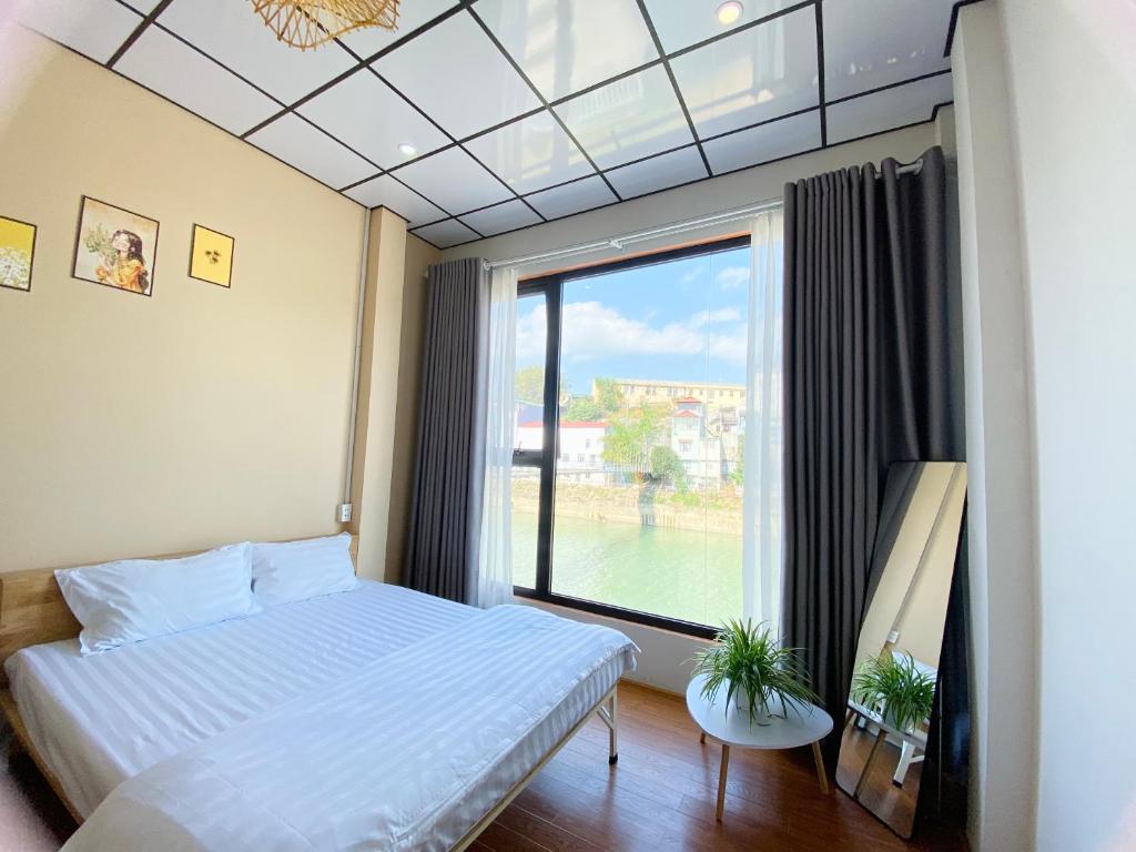 高平DH Homestay Cao Bằng的一间卧室设有一张床和一个大窗户